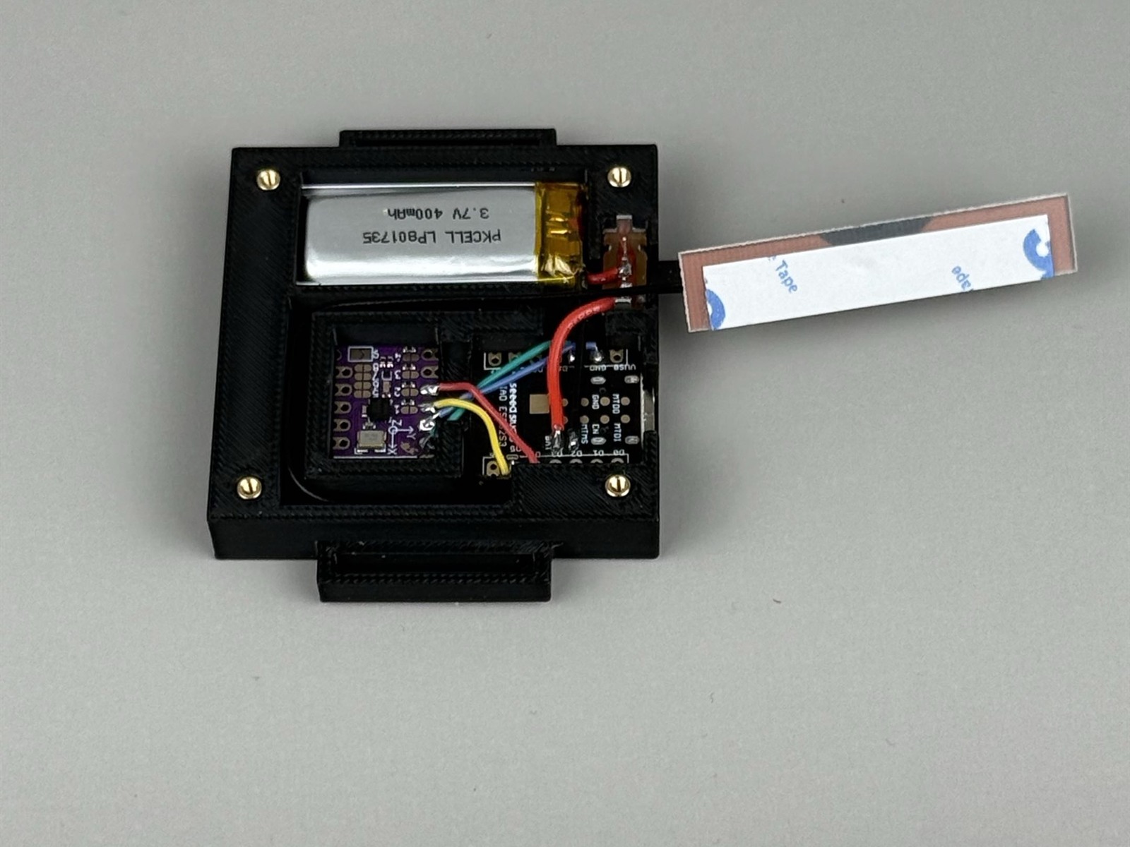 Open DIY SlimeVR tracker showing battery, controller board, IMU board, wiring, and antenna